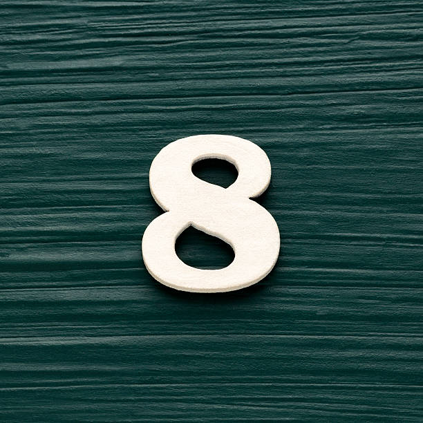 istock Number 8 white piece on a rustic dark green background 2230874557