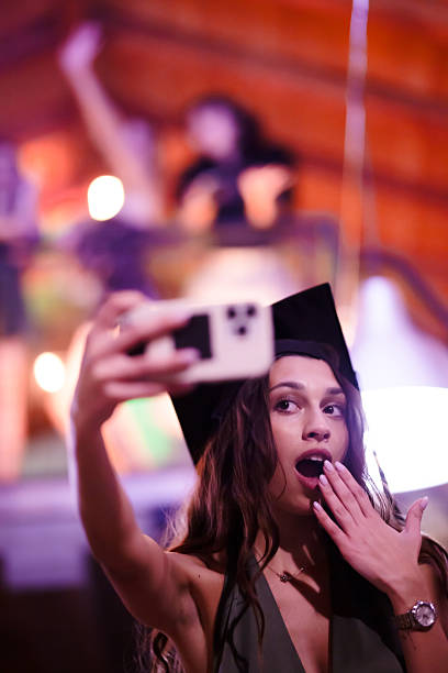istock Graduation selfie celebration with a surprised expression at a lively party 2230875162