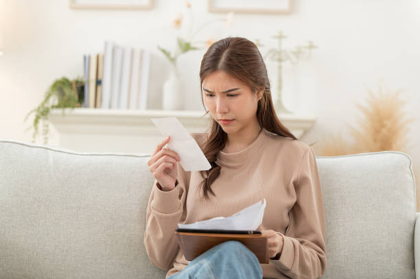 istock Asian woman feeling unhappy after looking at the bill feels stressed having financial problem, check finances, experiencing lack of money pay for loan, huge taxes, utility rates, get eviction notice 2230878986