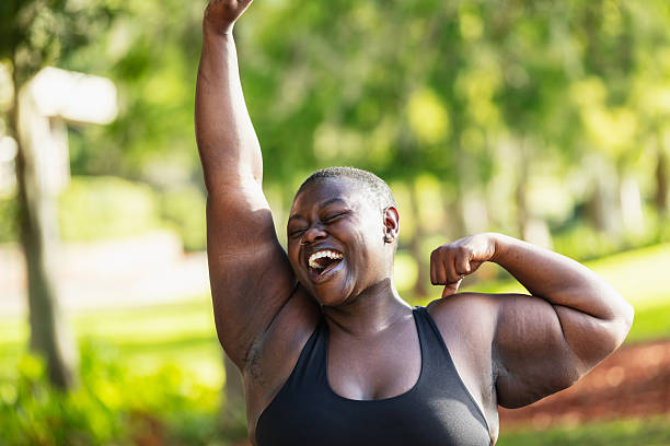 istock Black woman laughs as she stretches and  flexes her bicep 2230879108
