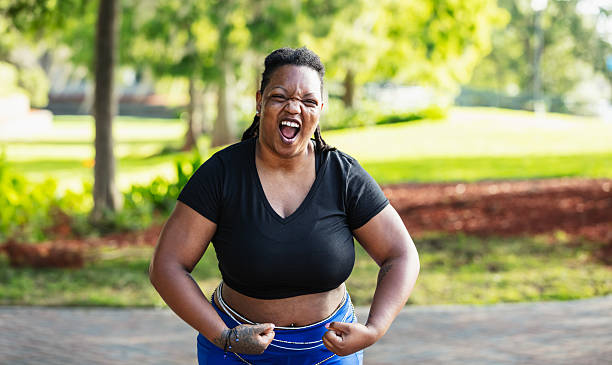 istock Black woman playfully flexes her biceps outdoors 2230879114