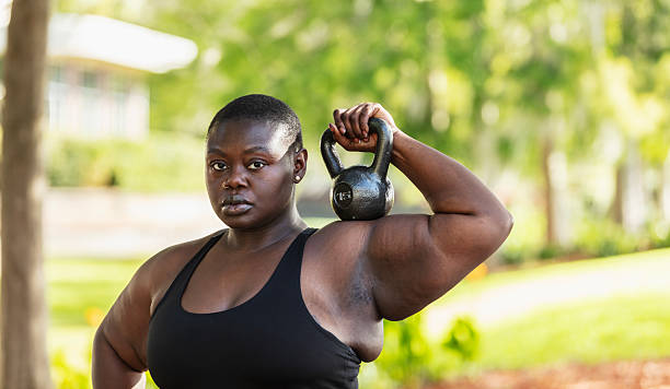 istock Black woman at park exercises with kettlebell 2230879176