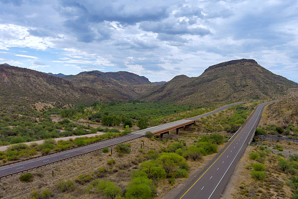 Highway intersection in desert landscape of Sunflower, Arizona roads with dramatic mountains rise Beeline Highway in Maricopa County Sonoran desert.