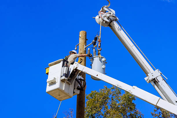 istock Utility worker performs maintenance on power lines during bright sunny day in urban area 2230881669