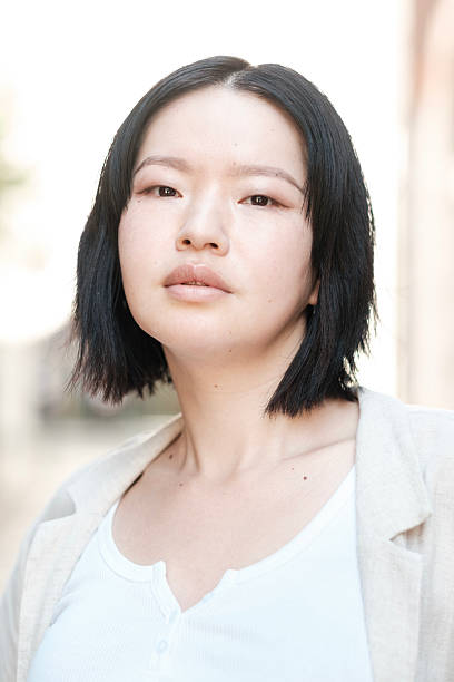 istock Young asian woman looking at camera with serious expression 2230888203
