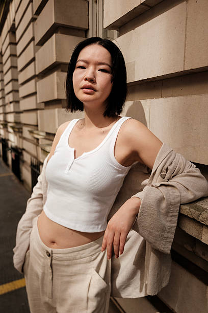 istock Young woman posing against a stone wall in urban setting 2230888238