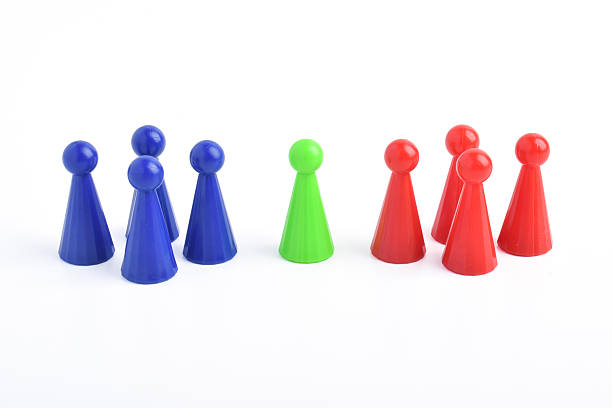 istock Green game piece facing two groups of pawns on white background 2230889943
