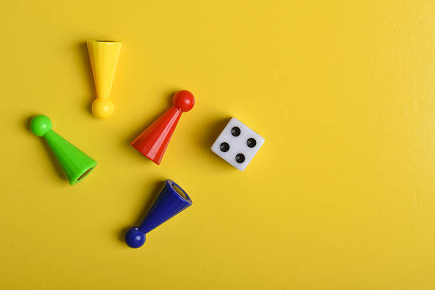 istock Colorful board game figures and dice on yellow background 2230892123