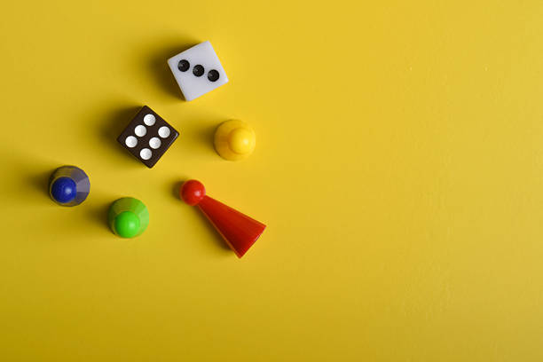 istock Colorful board game figures and dice on yellow background 2230892157