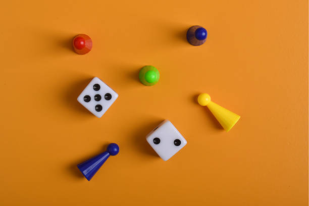 istock Colorful board game figures and dice on orange background 2230892187