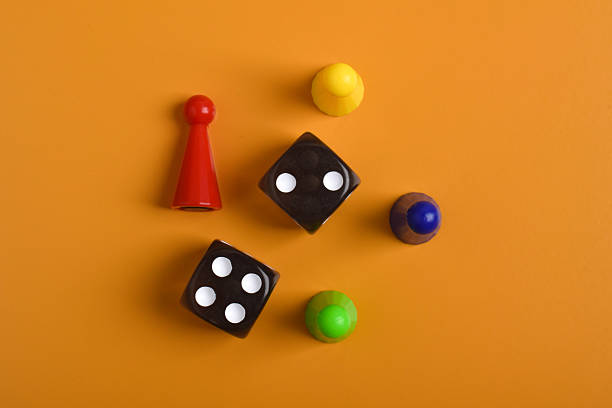 istock Colorful board game figures and dice on orange background 2230892200