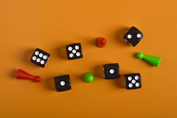 istock Colorful board game figures and dice on orange background 2230892233