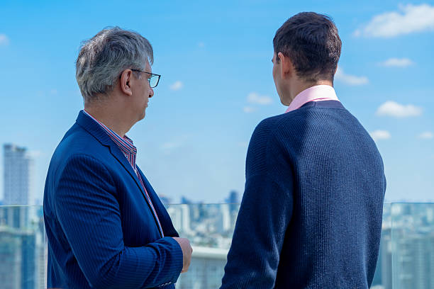 istock Business professionals engage in partnership discussions while overlooking city skyline, emphasizing negotiations and potential for successful agreement or deal 2230892628