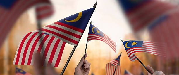 istock Malaysia flags in their hands on a blurred urban background 2230895562