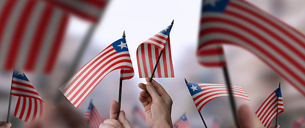 istock Liberia flags in their hands on a blurred urban background 2230895585