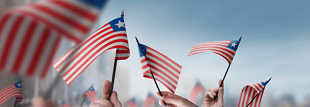 istock Liberia flags in their hands on a blurred urban background 2230895599