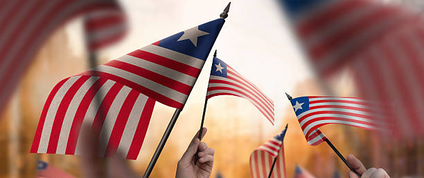 istock Liberia flags in their hands on a blurred urban background 2230895643