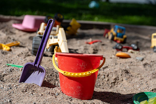 Colorful Plastic Buckets Scattered in a Children's Sandbox