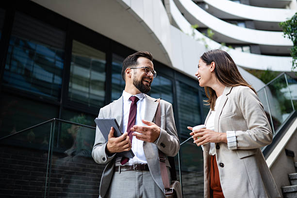 istock Business people talking and smiling outside office building 2230907607