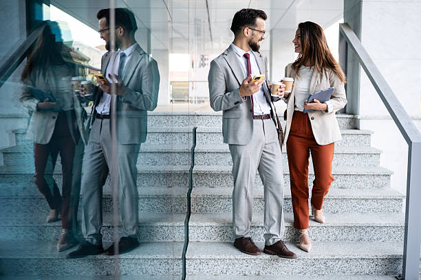 istock Business colleagues enjoying coffee break and discussing work on stairs 2230907971