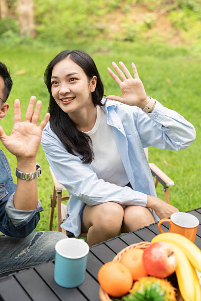 istock Happy couple waving and enjoying healthy snacks in a sunny garden. 2230909708