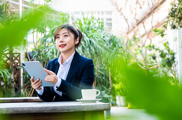 istock Businesswoman sitting at a cafe working on digital tablet 2230911002