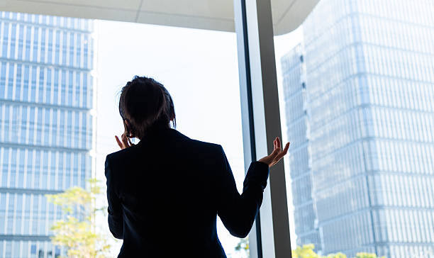 istock Businesswoman using smart phone near the window 2230911011