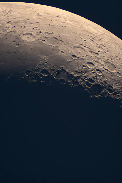 Detailed view reveals lunar surface craters near terminator. Astrophotograph of the Moonâs terminator line, showcasing sharply defined craters, rugged mountain ranges