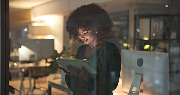 istock Businesswoman Working on a Tablet in a Modern Office at Night 2230913228