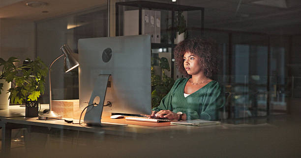 istock Focused Woman Working Late on Computer in Modern Office Environment 2230913236