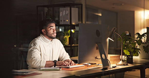 istock Focused Professional Working Late at a Modern Office Desk 2230913255