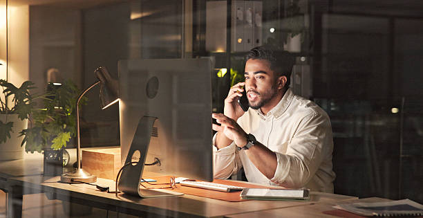 istock Professional Working Late at Desk Making a Phone Call in Evening Office 2230913285