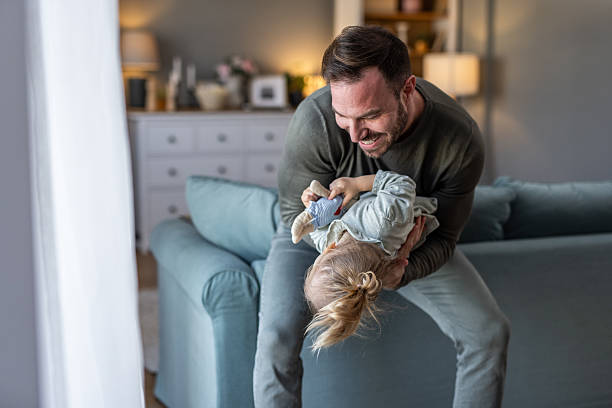 istock Father and daughter playing together on the sofa at home 2230914510