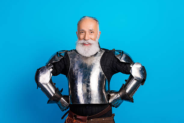 istock Smiling elderly man dressed as medieval knight in armor on a vibrant blue background showcasing costume and historical reenactment 2230915254