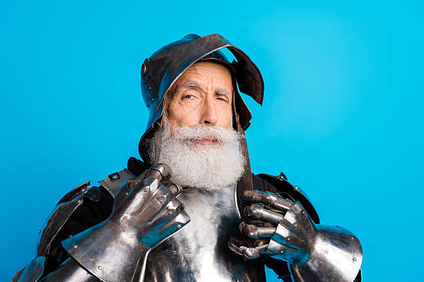 istock Senior man wearing medieval knight armor posing against a blue background with a confident expression 2230915309