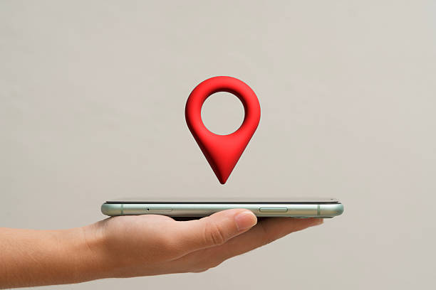 istock Hand holding smartphone with red location pin icon floating above symbolizing GPS, map, navigation, and travel 2230917633