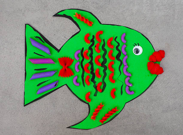 colorful pasta in different shapes used as details for a green cardboard fish craft