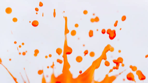 istock Dynamic orange watercolor splash with motion blur against a clean white background. Speed and energy and smaller orange splatters are scattered across the white space splash 2230924908