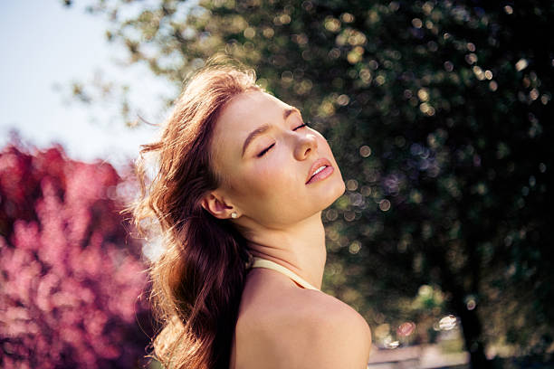 istock Lovely Young woman enjoying sunlight in a park setting with charming elegance 2230932350