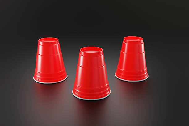 istock Three upside down red disposable plastic cups on a black background. Illustration of the concept of guessing, betting, unknown and games 2230935892