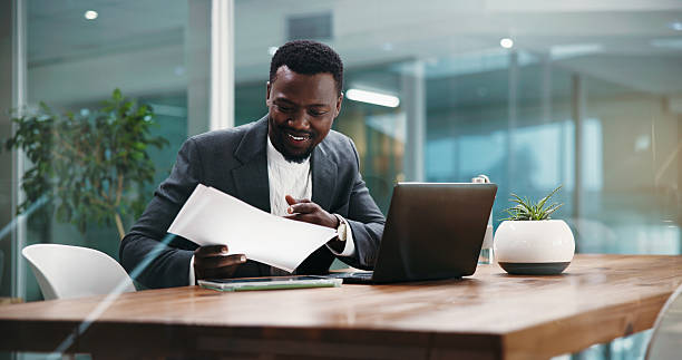 Man, documents and happy at office with finance review, problem solving and profit report at job. African person, broker and smile with paperwork for solution, feedback or revenue results at agency