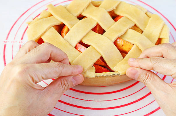 Weaving cut doughs on pie plate for lattice top crust of apple pie