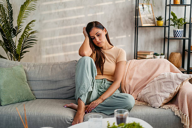 istock Sad Young Woman Sitting At Home On The Sofa 2230944759