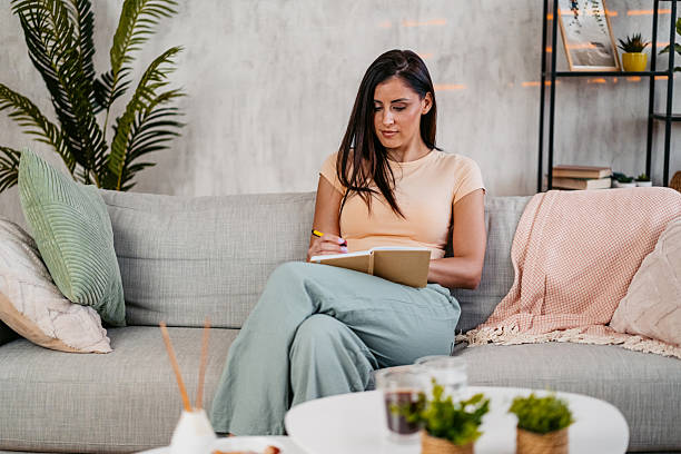 istock Young Woman Writing In A Diary At Home 2230945699