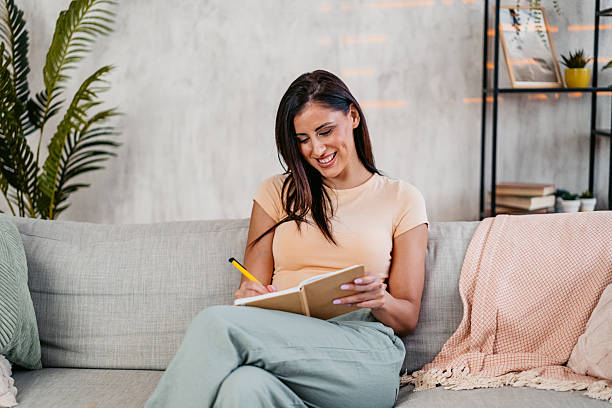 istock Young Woman Writing In A Diary At Home 2230945743