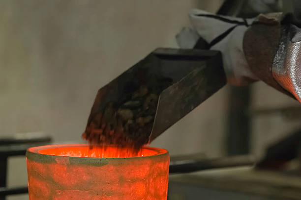 istock Scooping gold bearing ore into a smelting pot. 2230947611