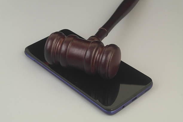 istock Smartphone and wooden gavel on grey 2230947740