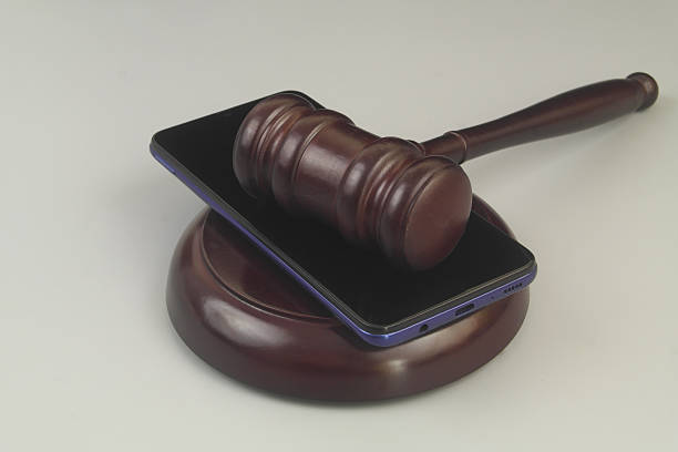 istock Smartphone and wooden gavel on grey 2230947818