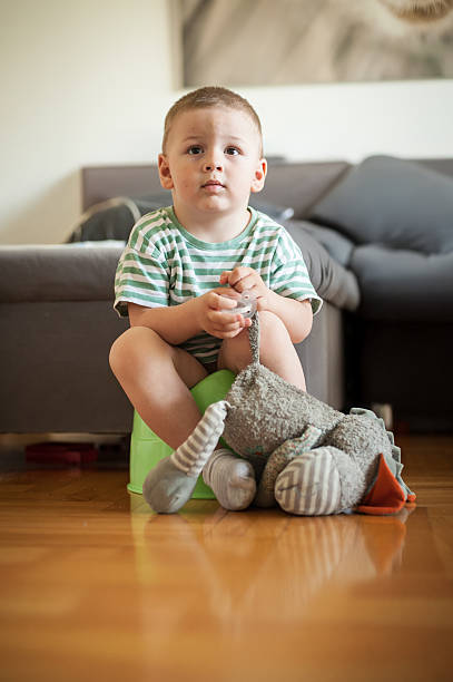 istock Child sits on a small stool in a living room holding a stuffed toy while looking thoughtfully at the camera 2230951115