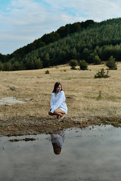 Woman Enjoying Scenic Landscape With Tranquil Water Reflection